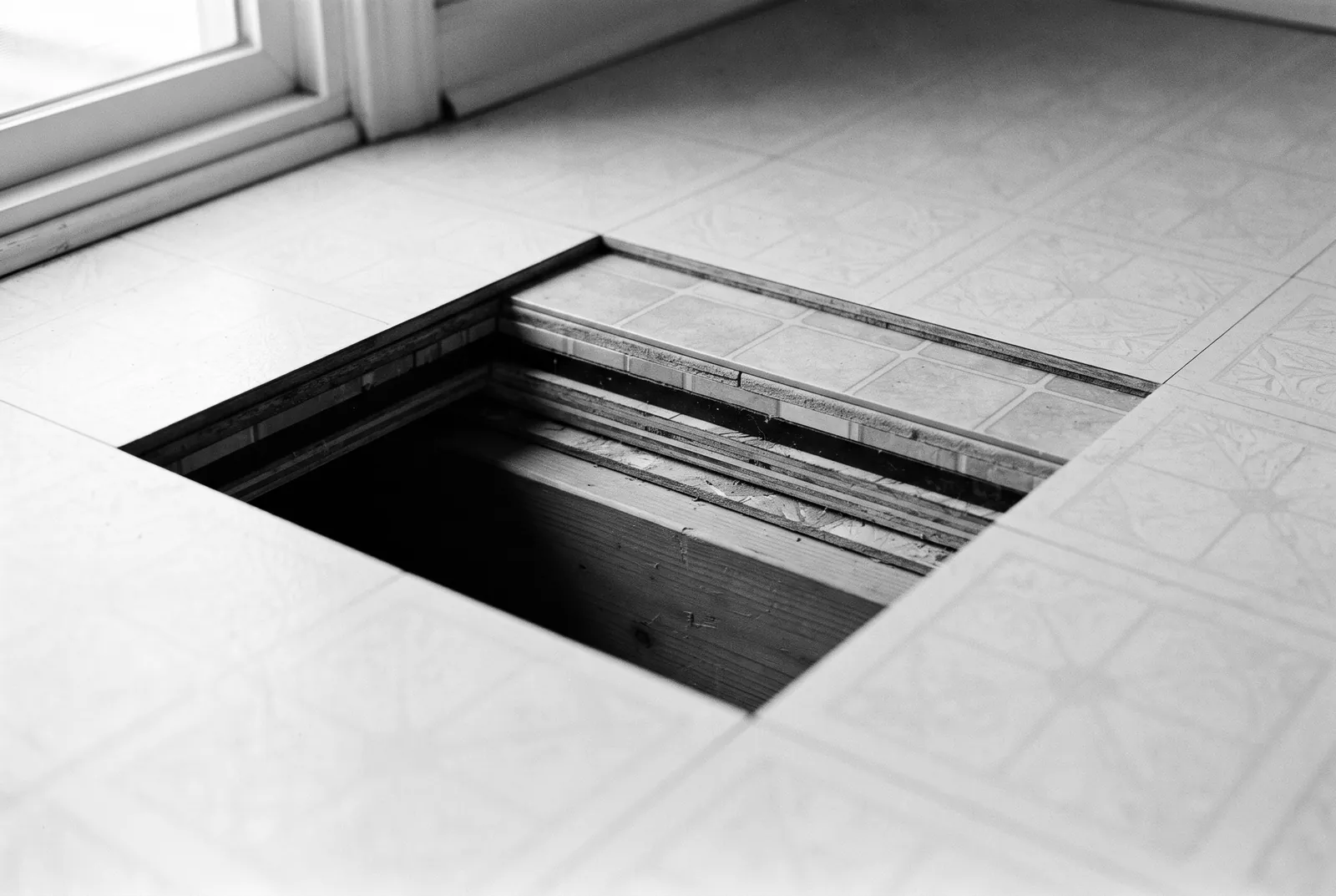 Render of a square cut in an old kitchen floor, showing the layers of flooring down to a wooden joist.